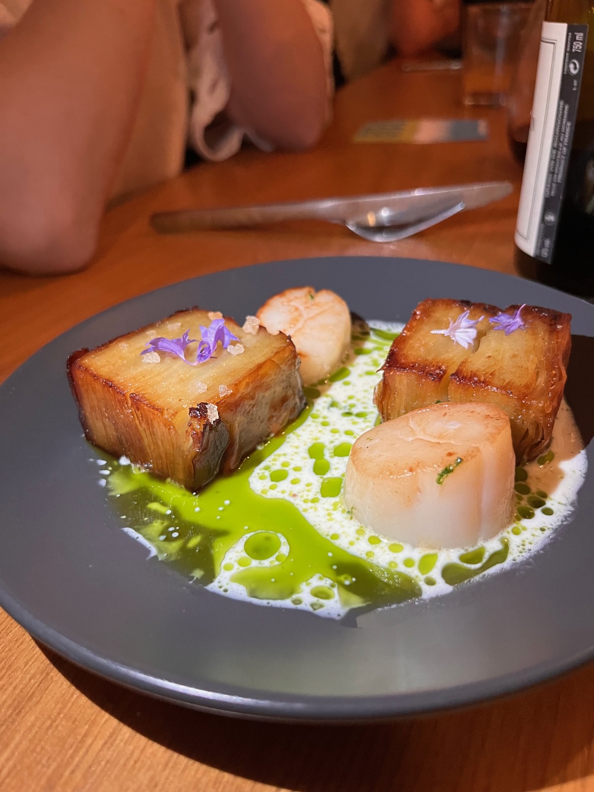 Seared scallops and a caramelized terrine in herb oil